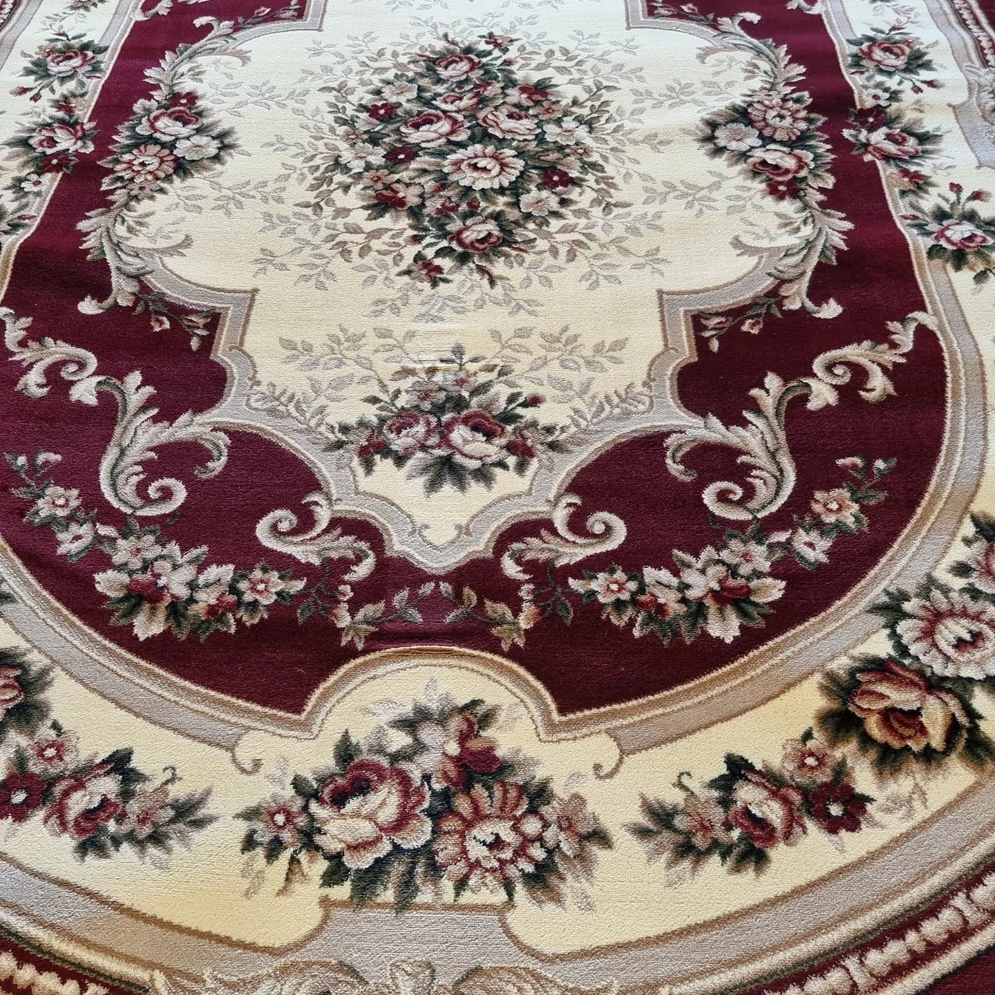 Detaliu model floral central pe covor clasic grena