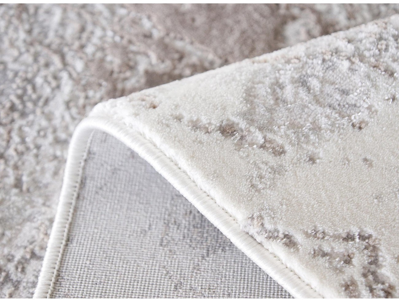 Detaliu margine si textura covor modern crem bej, material moale si rezistent
