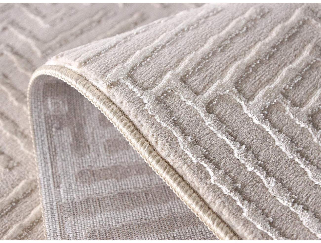 Detaliu model geometric texturat pe covor crem modern, fibre moi si confortabile