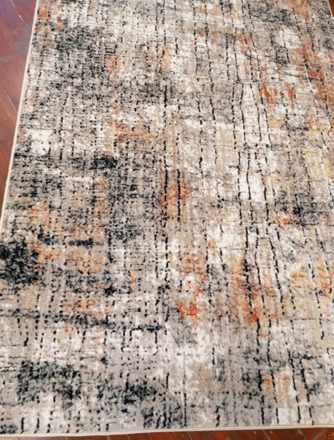Detaliu textura covor modern gri bej cu accente caramizii design abstract rezistent si usor de intretinut
