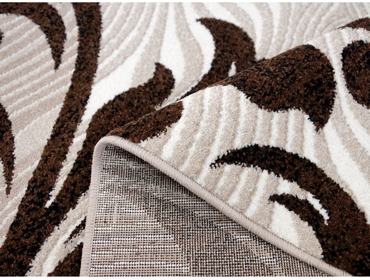 Detaliu textura covor oval modern cu model maro reliefat si fir moale