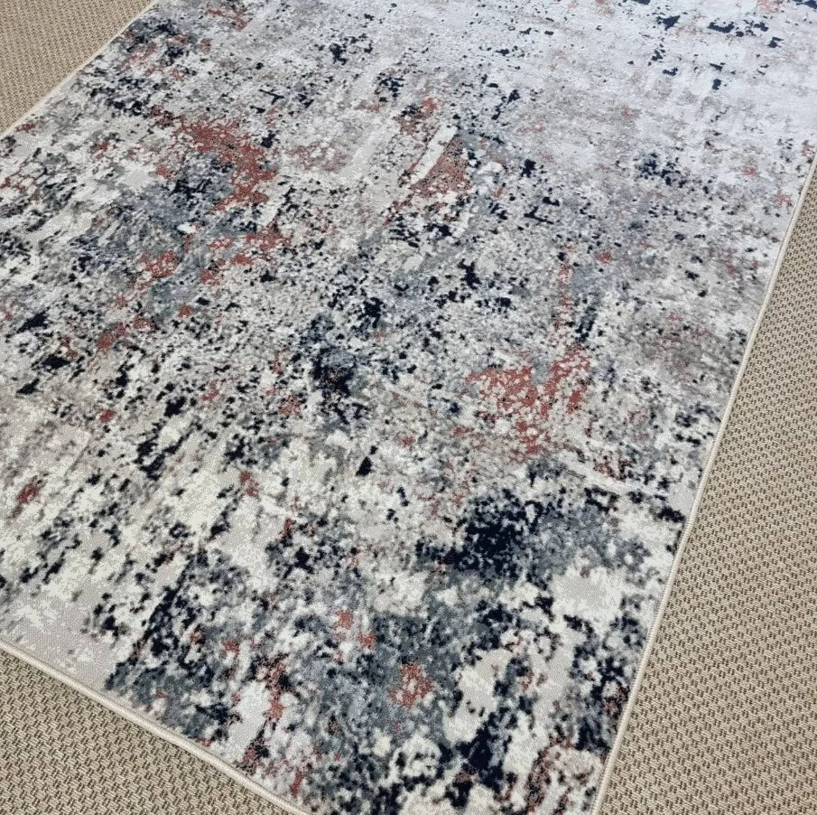 Detaliu model abstract cu nuante bej gri si accente caramizii pe covor modern