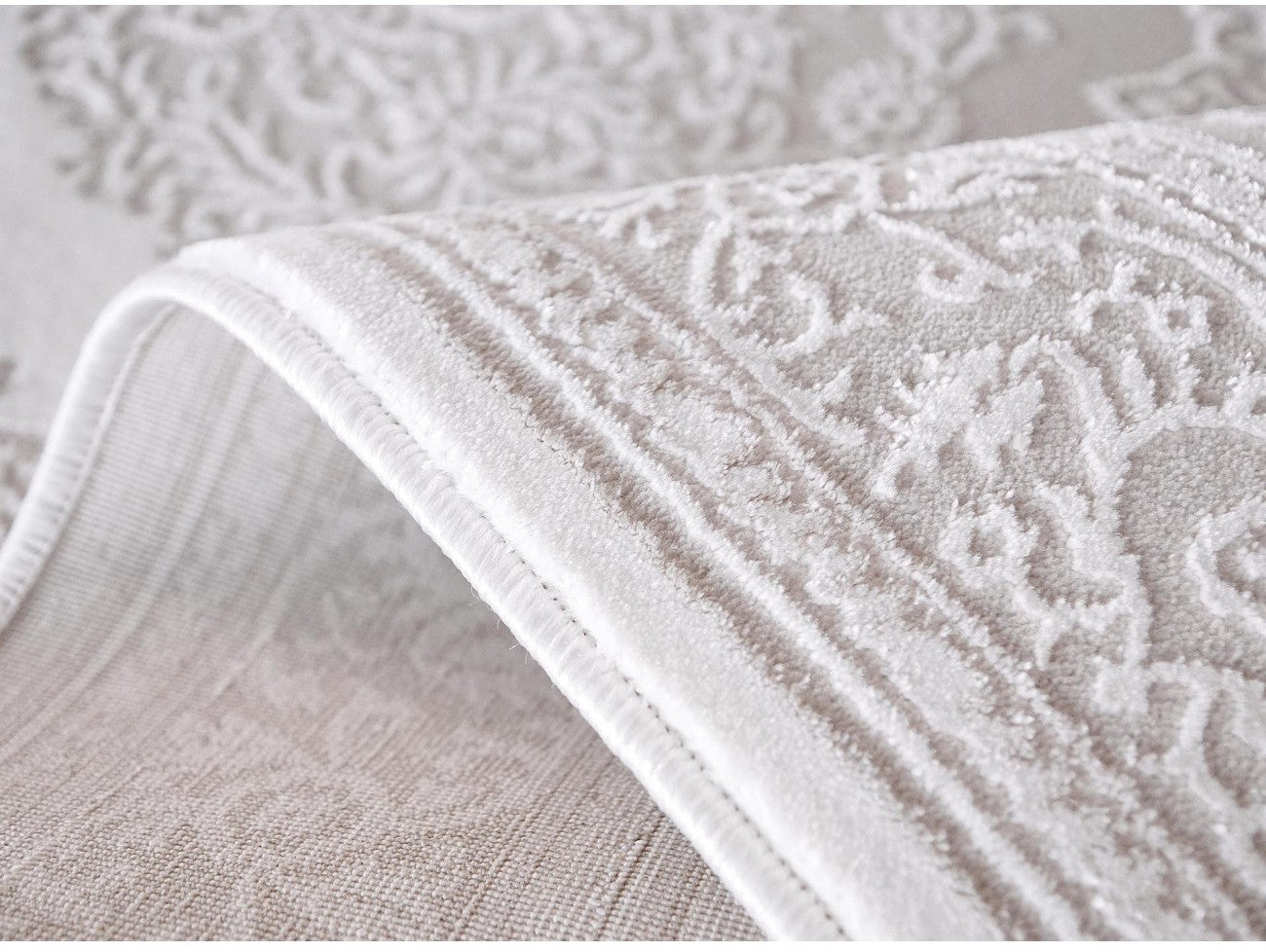 Detaliu model ornamental floral crem, covor clasic cu finisaje elegante si relief delicat