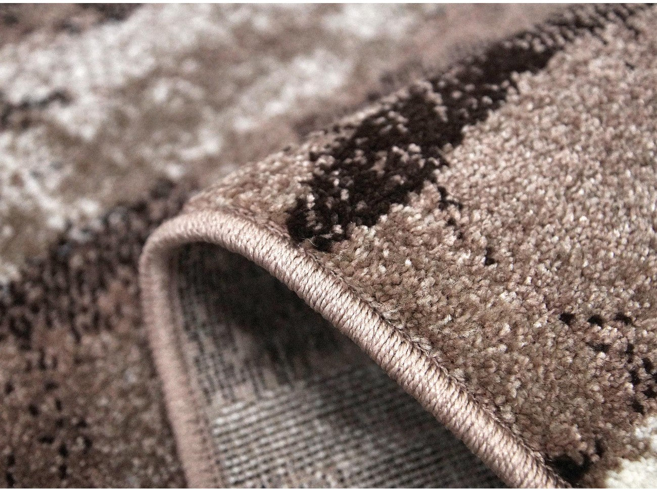 Detaliu textura traversa covor maro cu model geometric, material rezistent pentru trafic intens