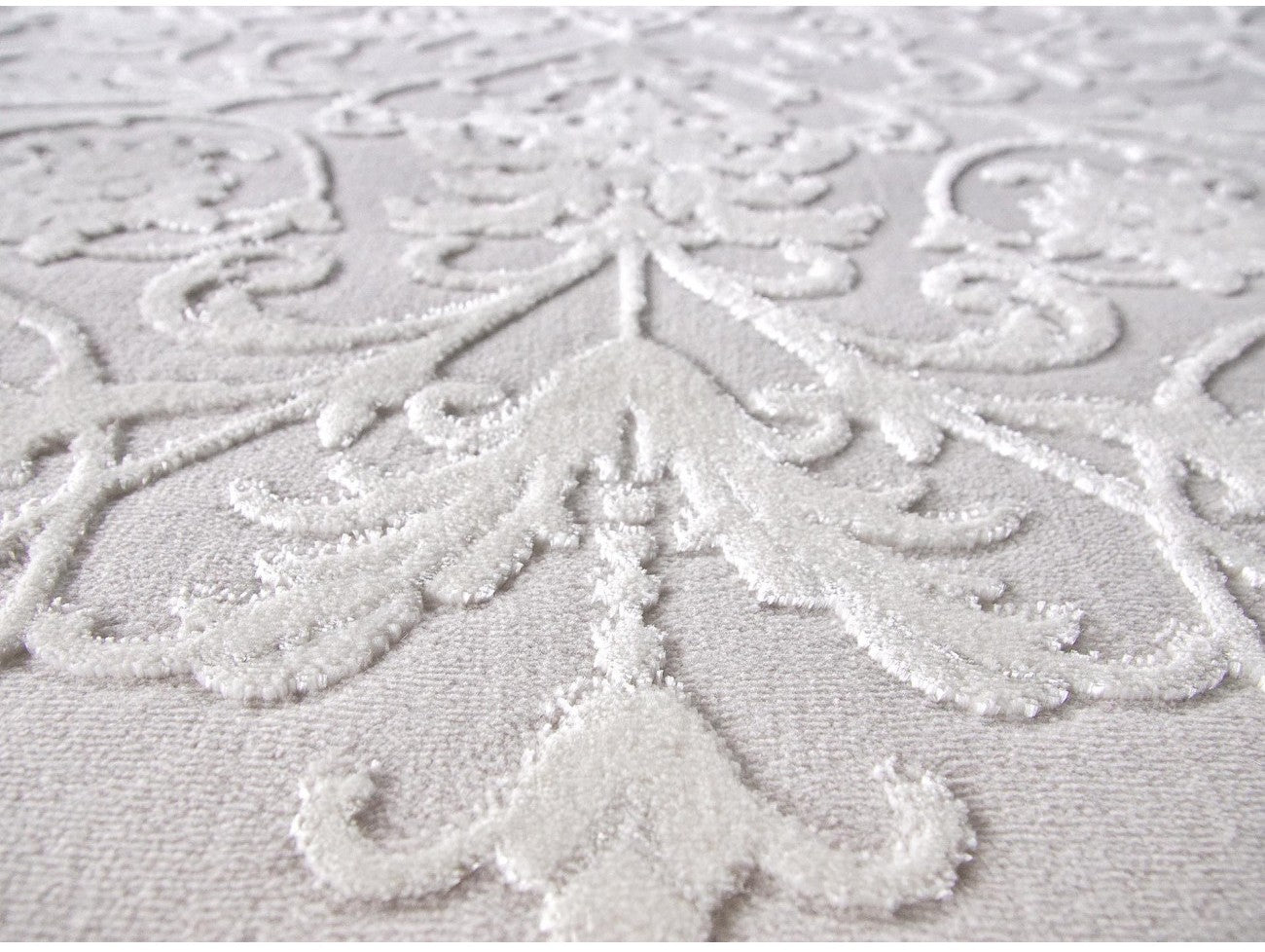 Detaliu traversa alba cu model floral in relief si textura fina